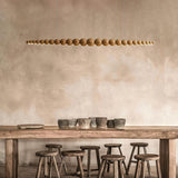 A modern kitchen with linear pendant lights hanging above a countertop, offering an elegant and functional light source.
