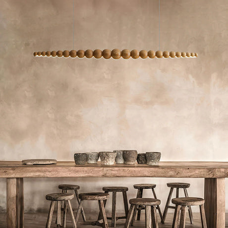 A modern kitchen with linear pendant lights hanging above a countertop, offering an elegant and functional light source.