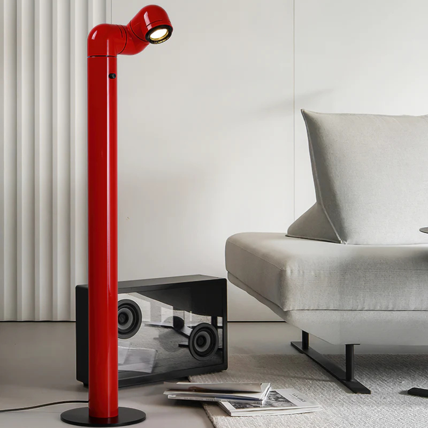 A red floor lamp positioned next to a window, casting light on the surrounding space.