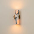 Modern marble wall sconce with soft up-and-down lighting mounted on a neutral beige wall.