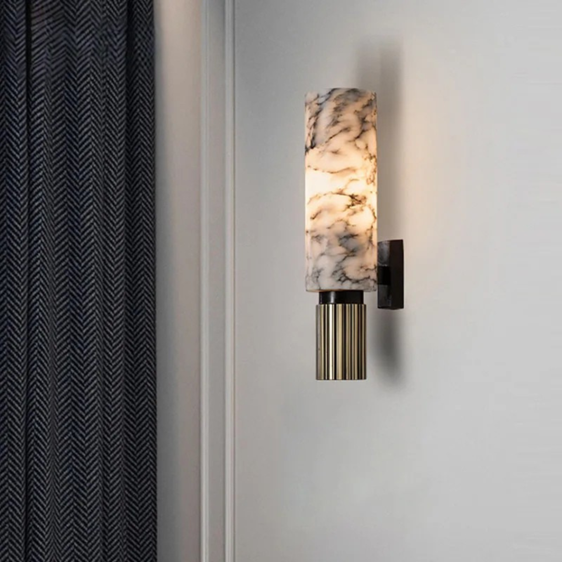 Elegant marble cylindrical wall light fixture adding warm ambient glow to a modern space.