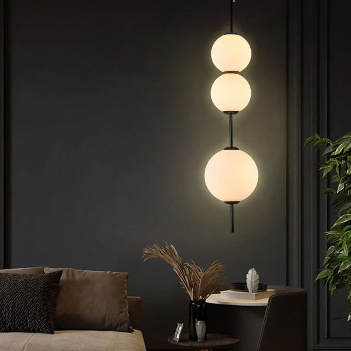 A view of a minimalist bedroom with three round pendant lights glowing softly against a dark wall.