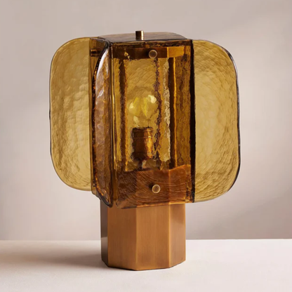 Amber glass desk lamp with geometric shade and wooden base displayed against a neutral background