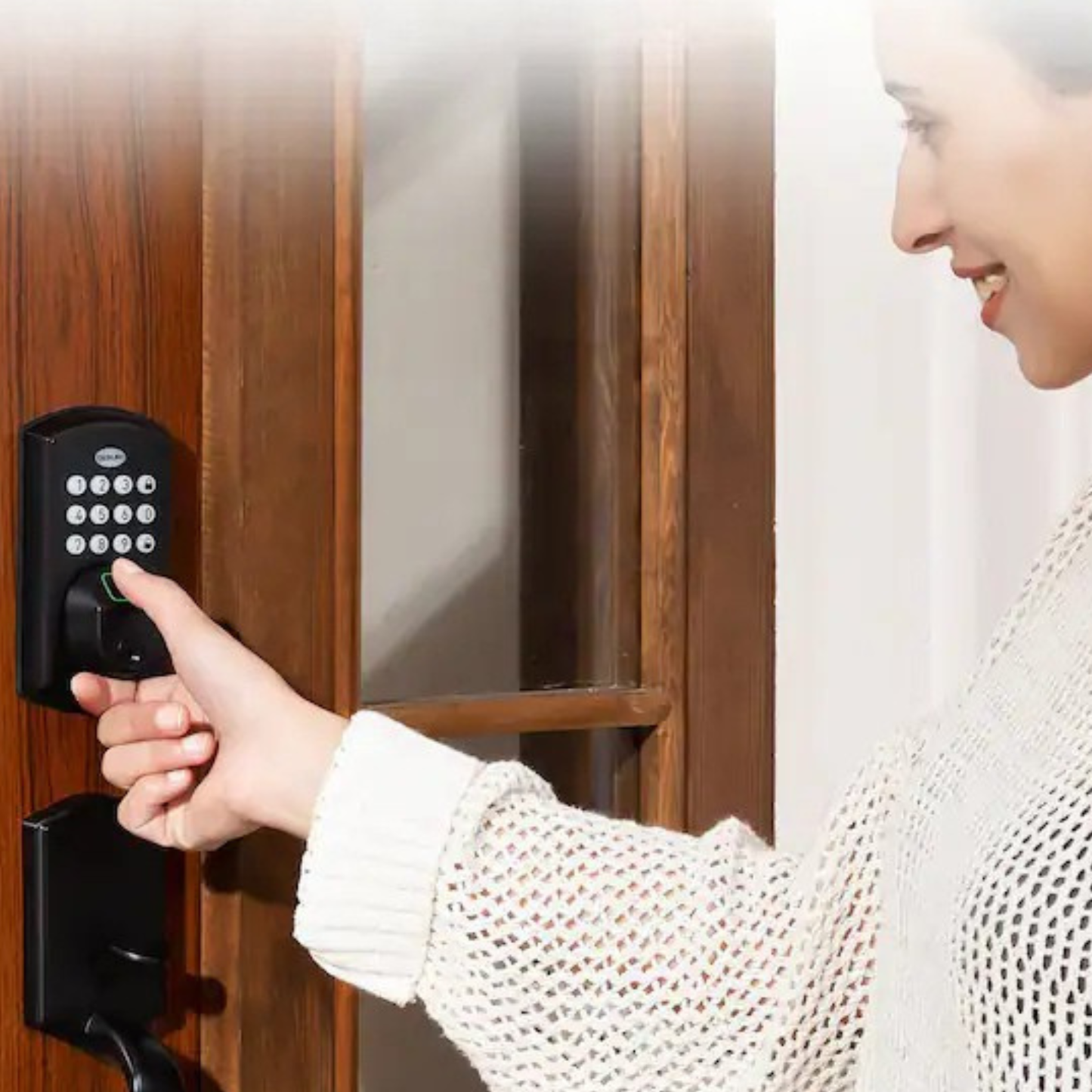 A woman using a keypad smart lock on a white front door while carrying a bag.