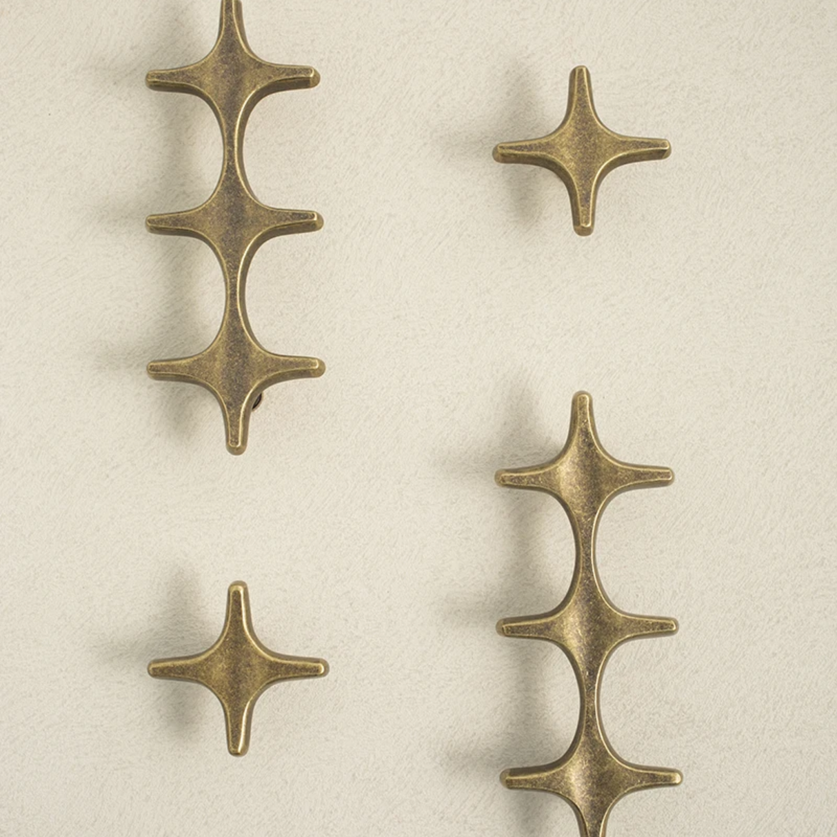 Set of four bronze decorative elements on a beige background