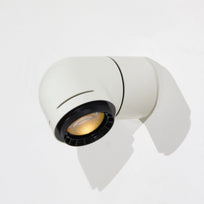 A close-up of a red wall-mounted light fixture, with the light illuminating the wall beneath it.