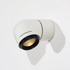 A close-up of a red wall-mounted light fixture, with the light illuminating the wall beneath it.