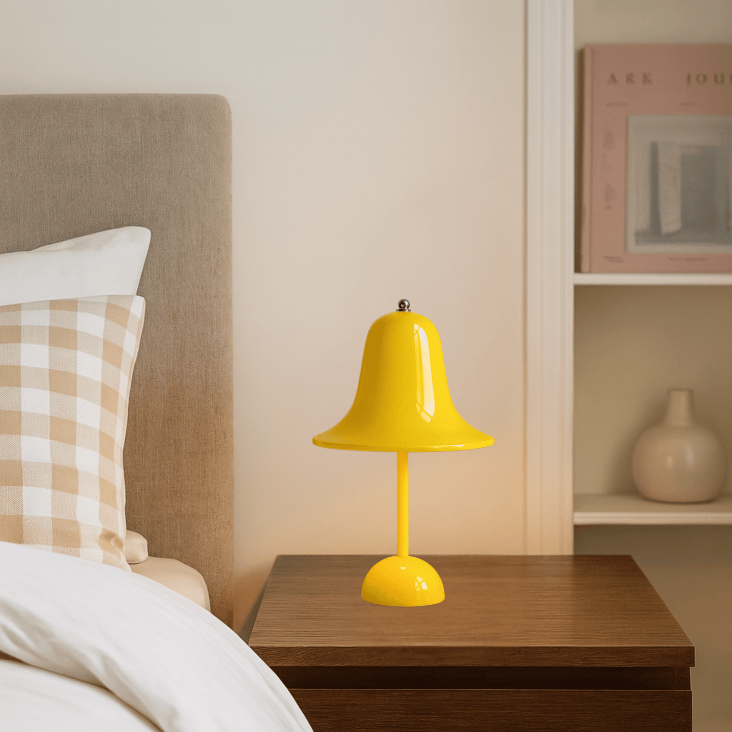Yellow table lamp on a wooden nightstand next to a bed with checkered pillows.