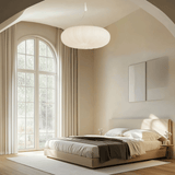 Modern bedroom with a large window, bed, and decorative elements.