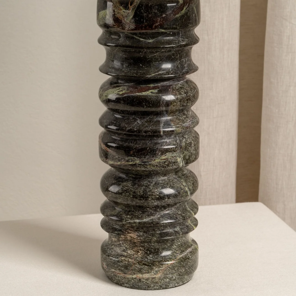 Decorative black stone column on a neutral background