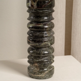 Decorative black stone column on a neutral background