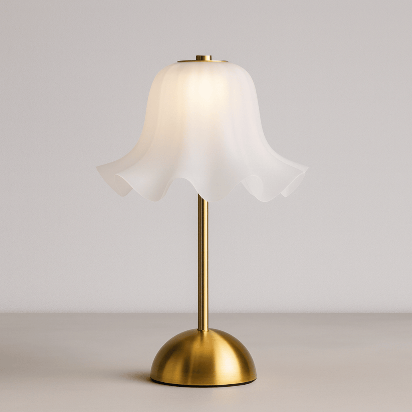 Table lamp with white shade and gold base on a neutral background