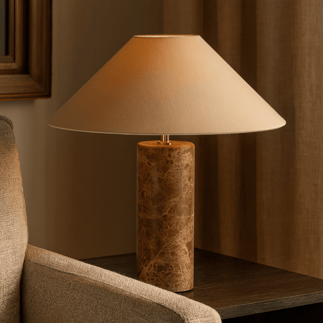 Table lamp with a textured base on a wooden surface next to a chair.