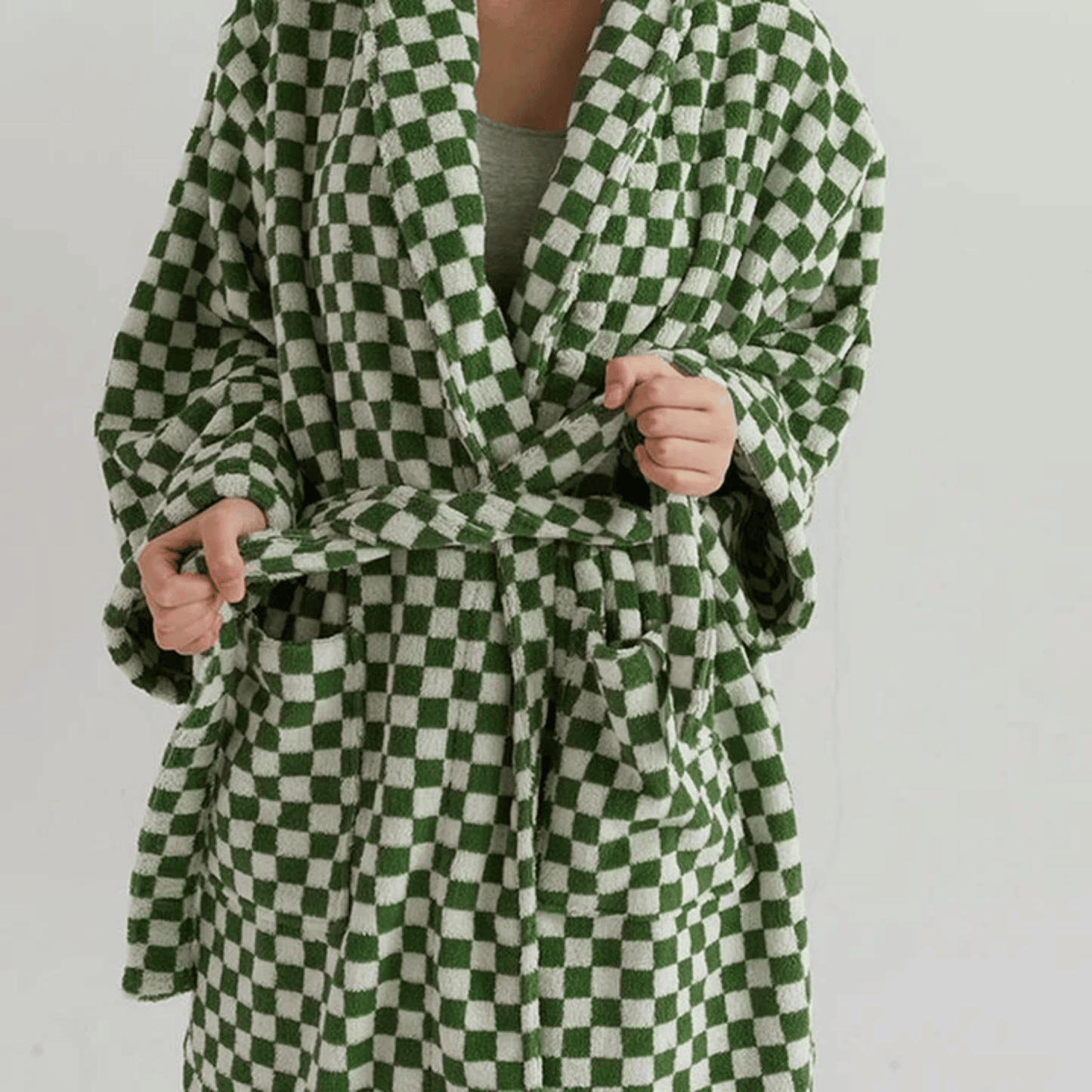 Green and white checkered robe worn by a person on a plain background