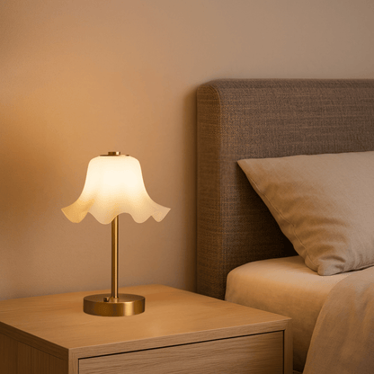 Lamp on a nightstand next to a bed with a beige headboard and pillow.