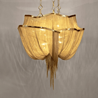 Gold chandelier with fabric shade on a gray background