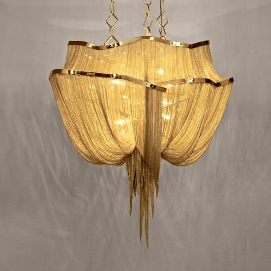 Gold chandelier with fabric shade on a gray background