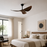 Modern bedroom with a ceiling fan, bed, and decor elements.