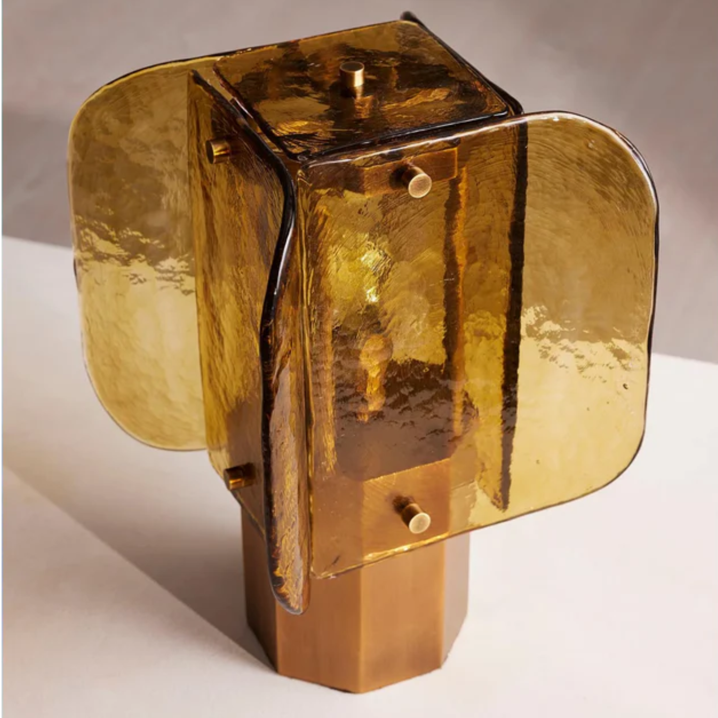 Side view of handcrafted amber glass lamp showing its curved glass panels and elegant warm tone