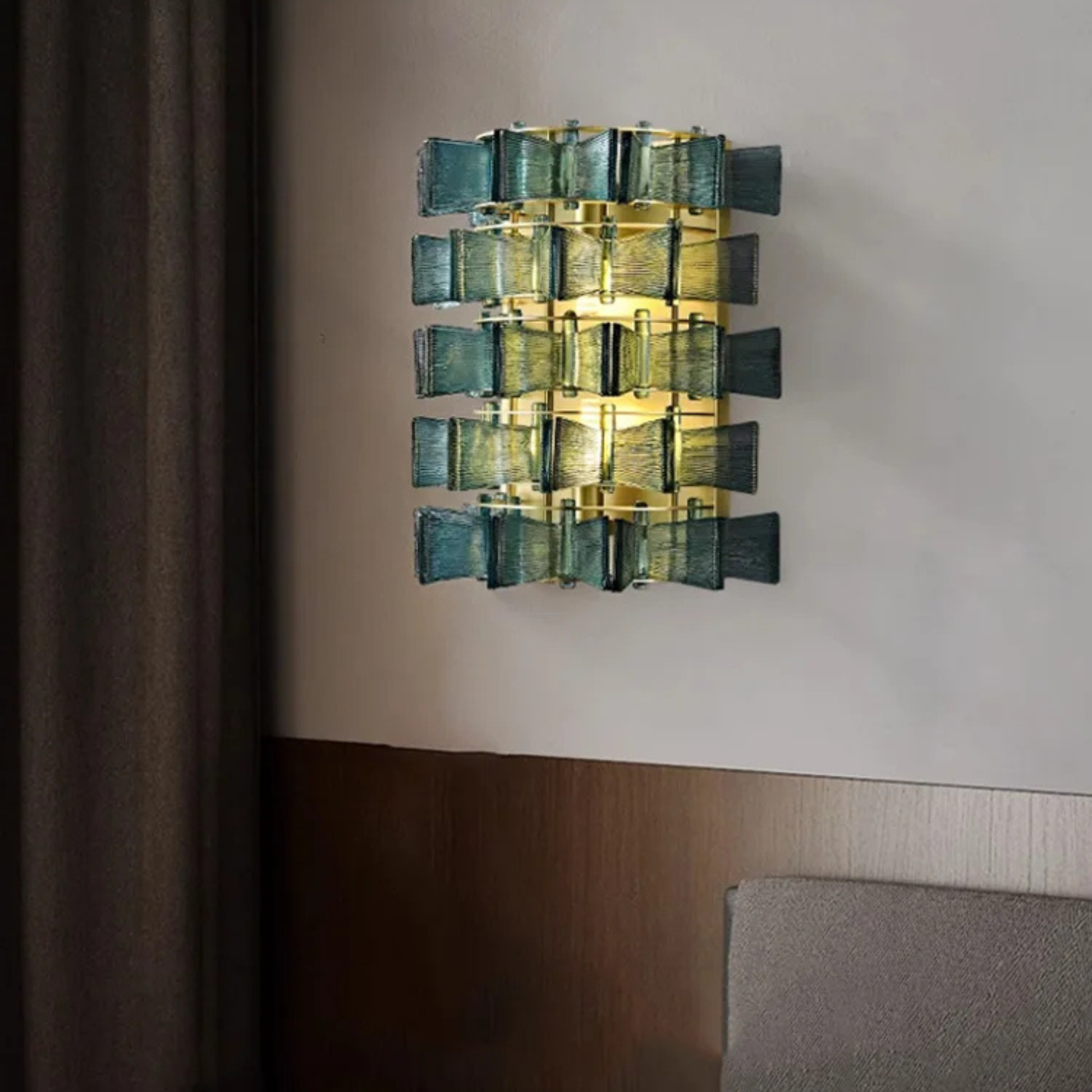 Close-up view of a teal version of the ribbed glass light with gold metal detailing.