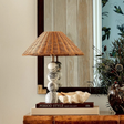 The lamp beside a bed in a minimalist bedroom setup, adding a soft decorative touch.