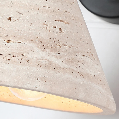 Close-up view of the lamp’s textured stone cone shade with a warm yellow light inside.