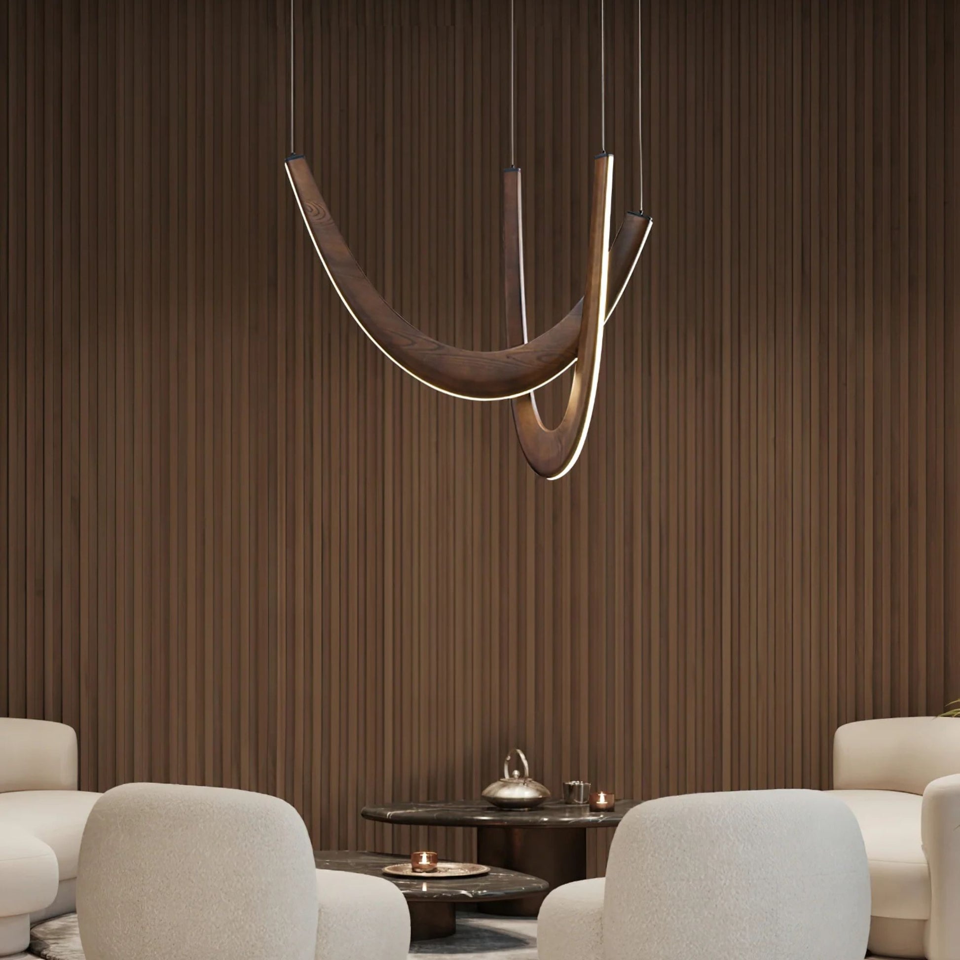 A sleek, modern dining space with a pendant light featuring two curved wooden arms above a round table.