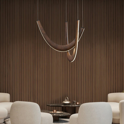 A sleek, modern dining space with a pendant light featuring two curved wooden arms above a round table.
