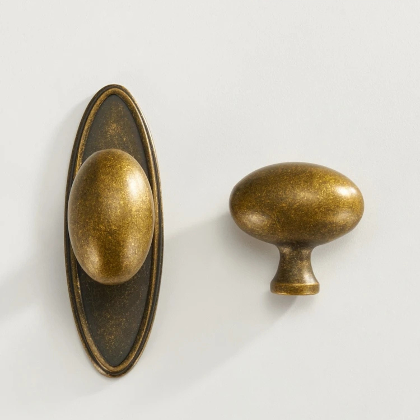 A single vintage brass knob installed on a wall, casting a soft shadow.