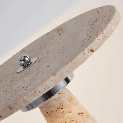 Close-up of a stone surface with a metallic object on a light gray background