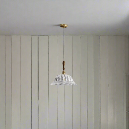 Pendant light with crystal shade and gold fixture on a beige background