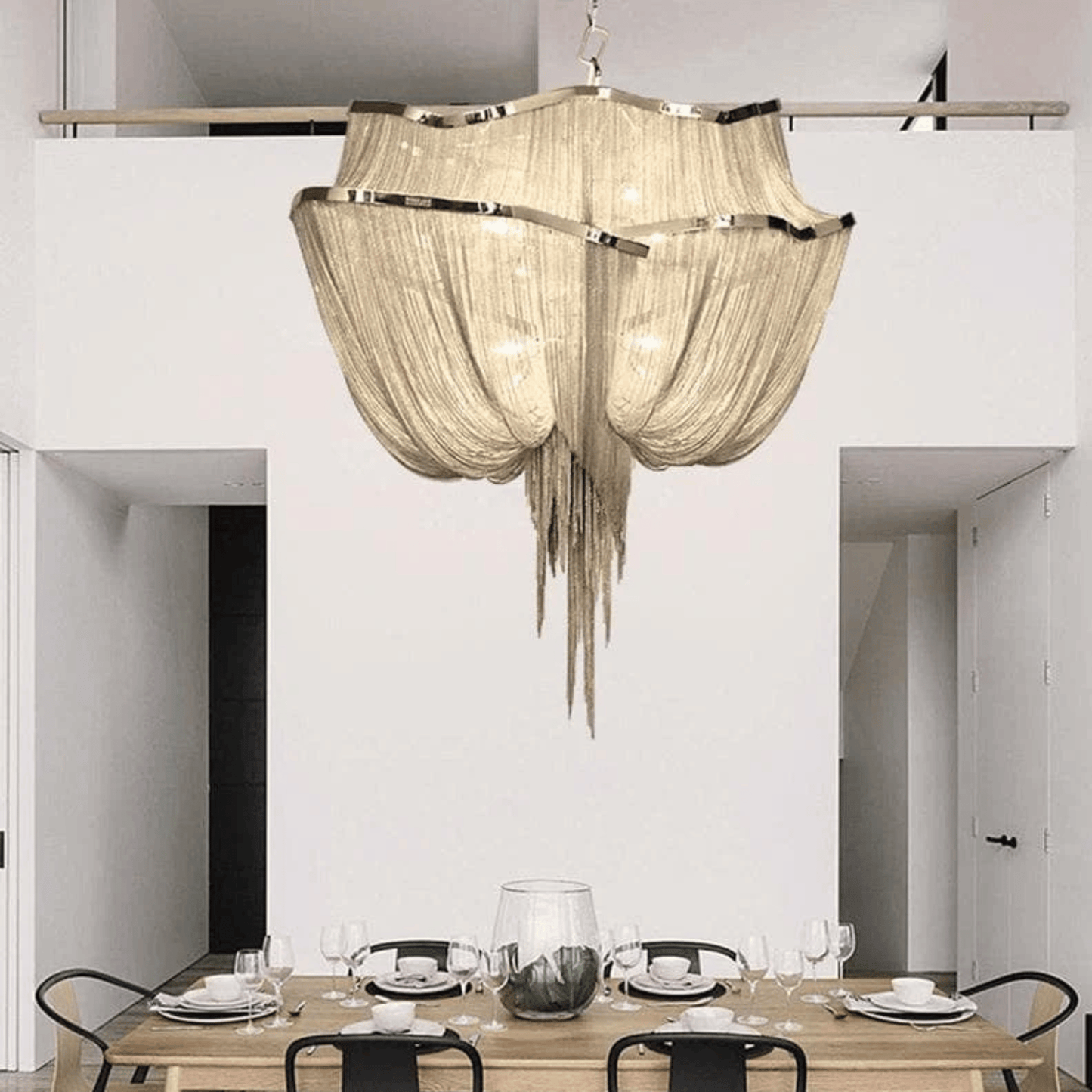Chandelier hanging above a dining table in a modern interior setting.