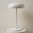 White table lamp on a stand with a beige backround