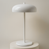 White table lamp on a stand with a beige backround
