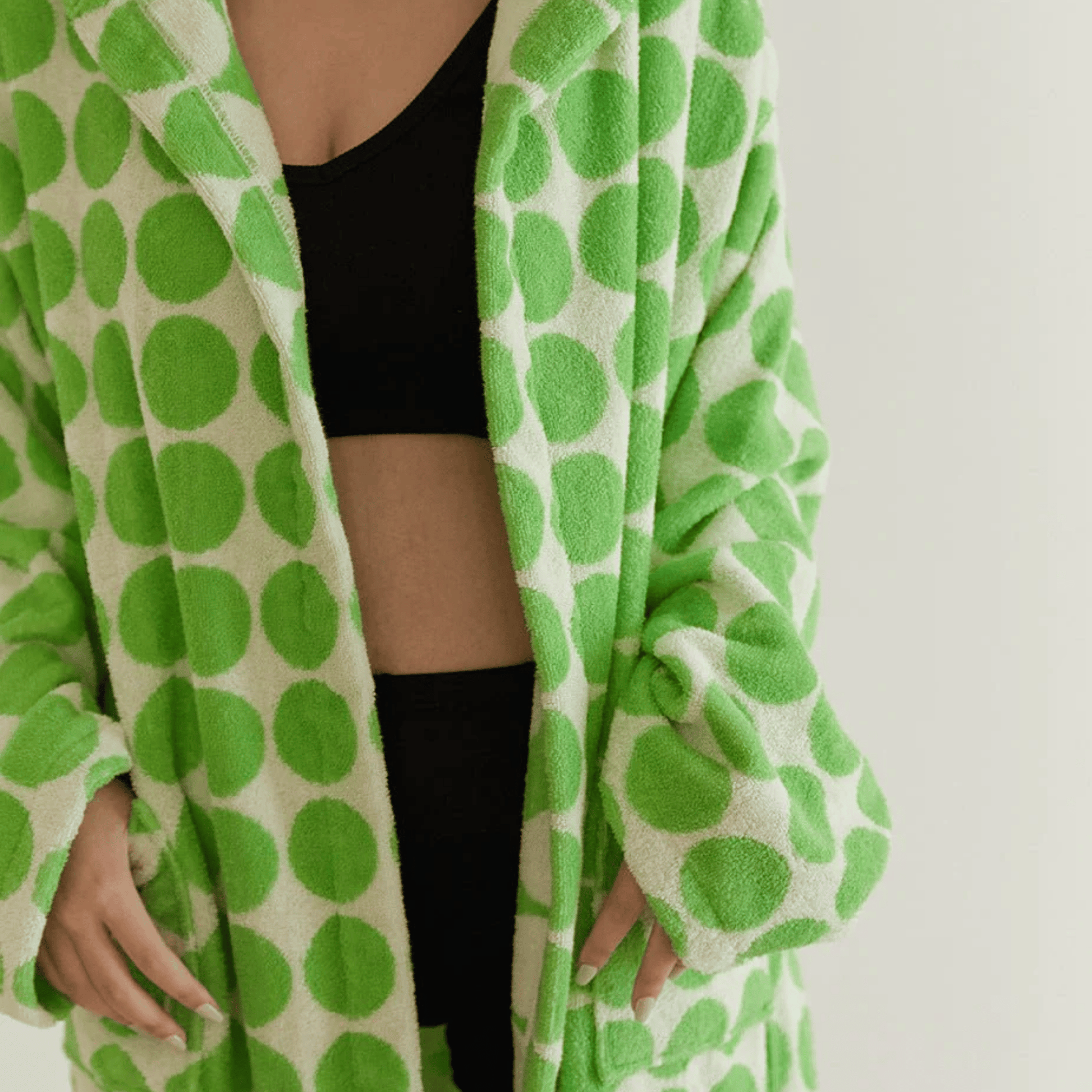 Green and white polka dot robe draped over a person on a plain background