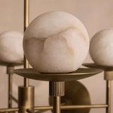 Marble sphere on a gold stand with a warm beige background