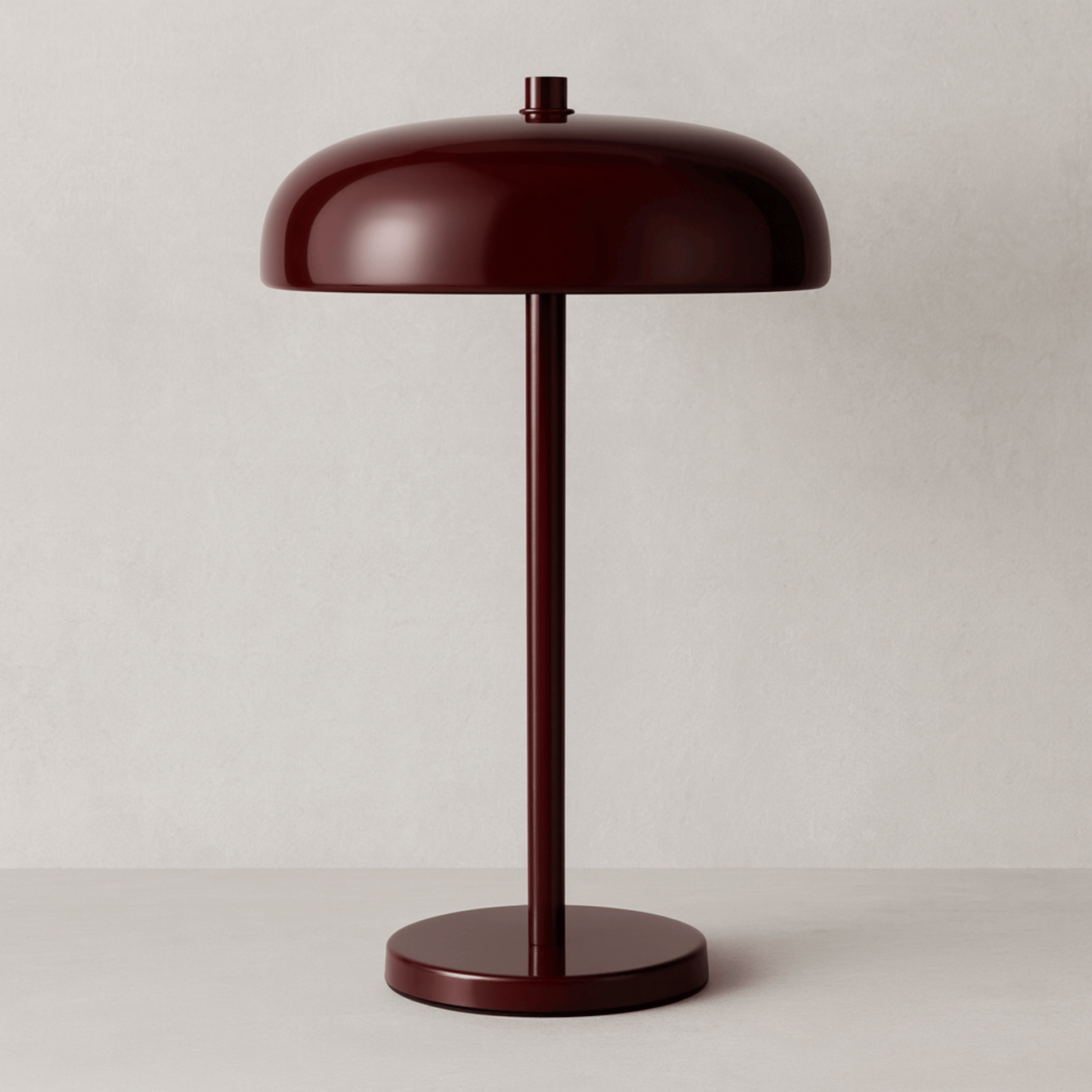 Red table lamp on a stand with a beige backround