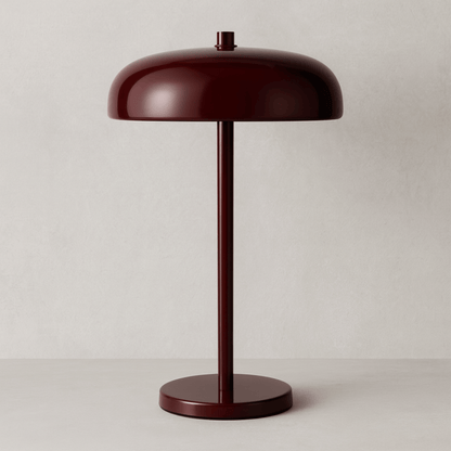 Red table lamp on a stand with a beige backround