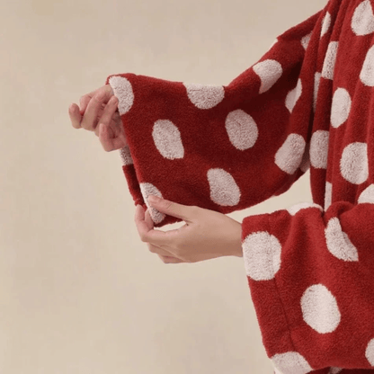 Red polka dot towel being held against a beige background