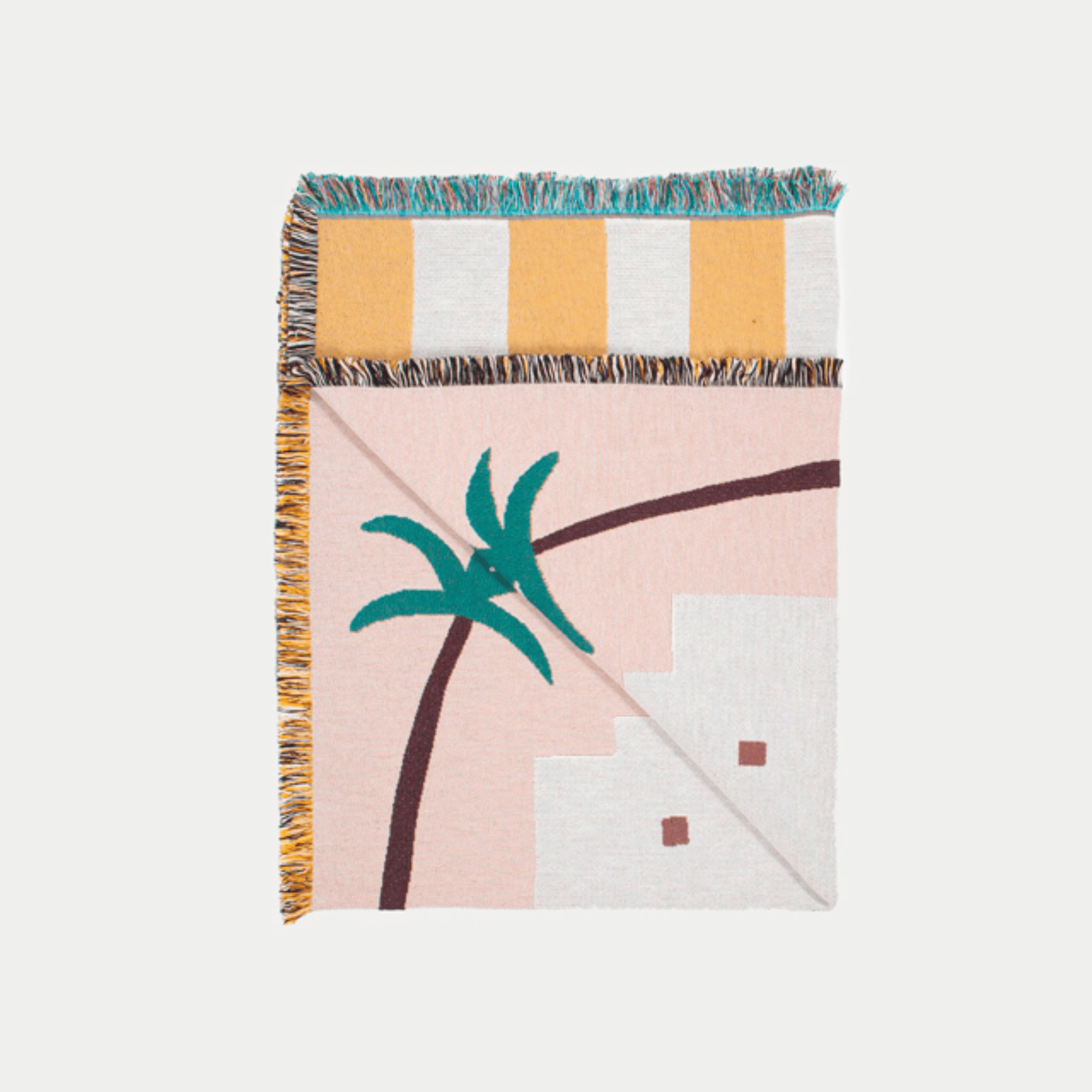 Decorative blanket with palm tree and building design on a light pink background