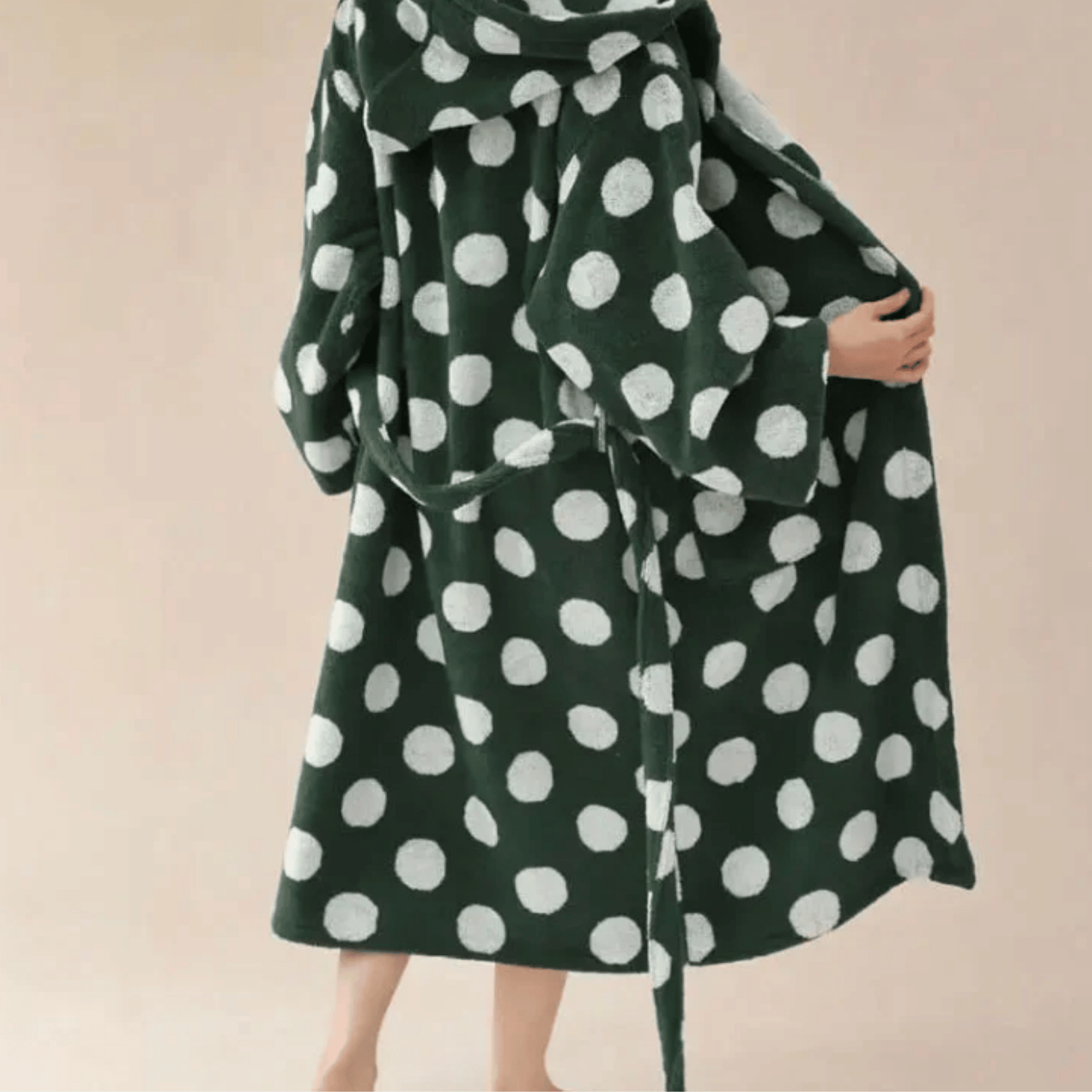Green coat with white polka dots on a beige background