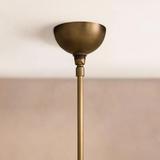 Brass ceiling light fixture against a beige wall
