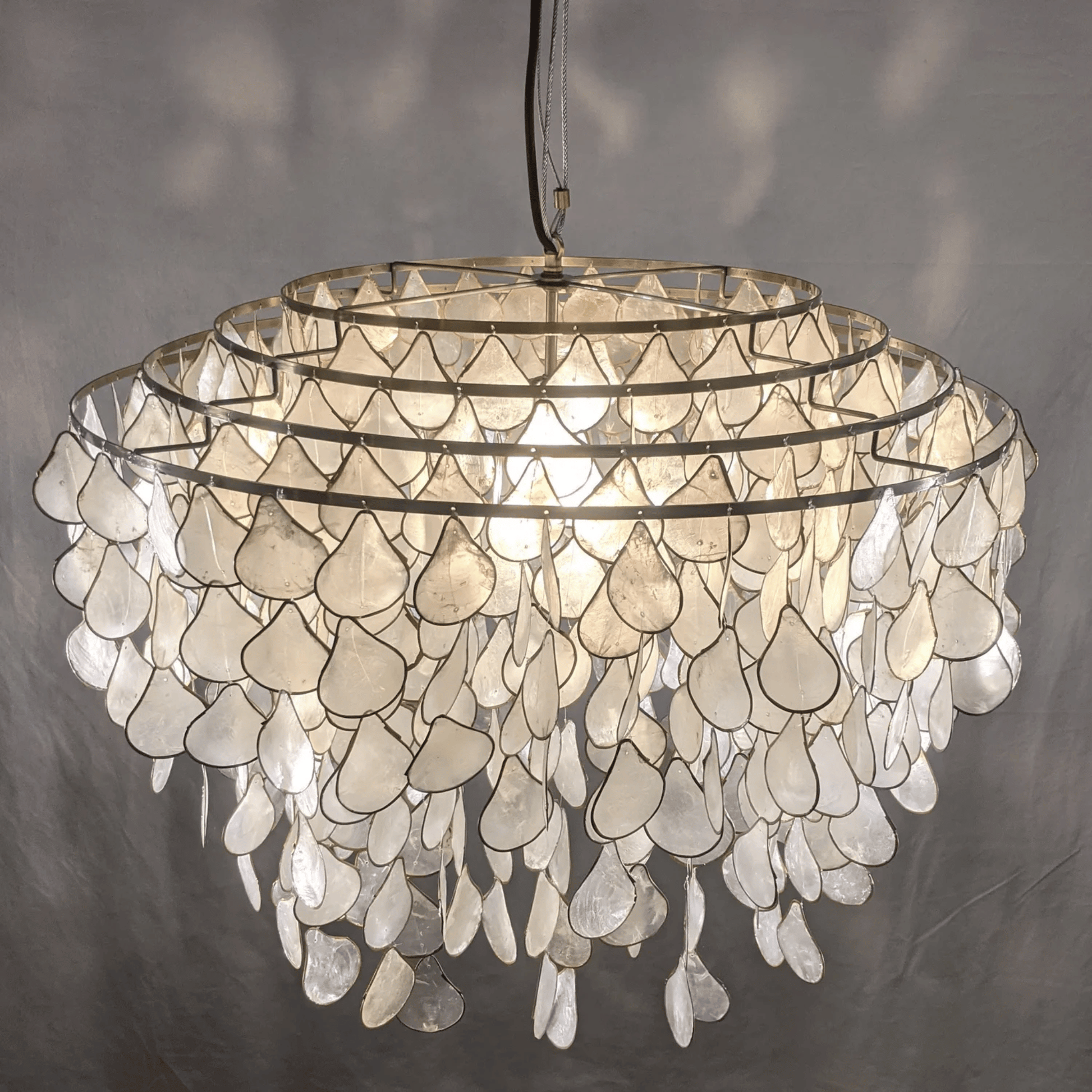 Chandelier made of shell-like materials on a gray background