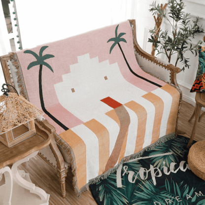 Decorative blanket with palm tree design on a chair in a room with plants.