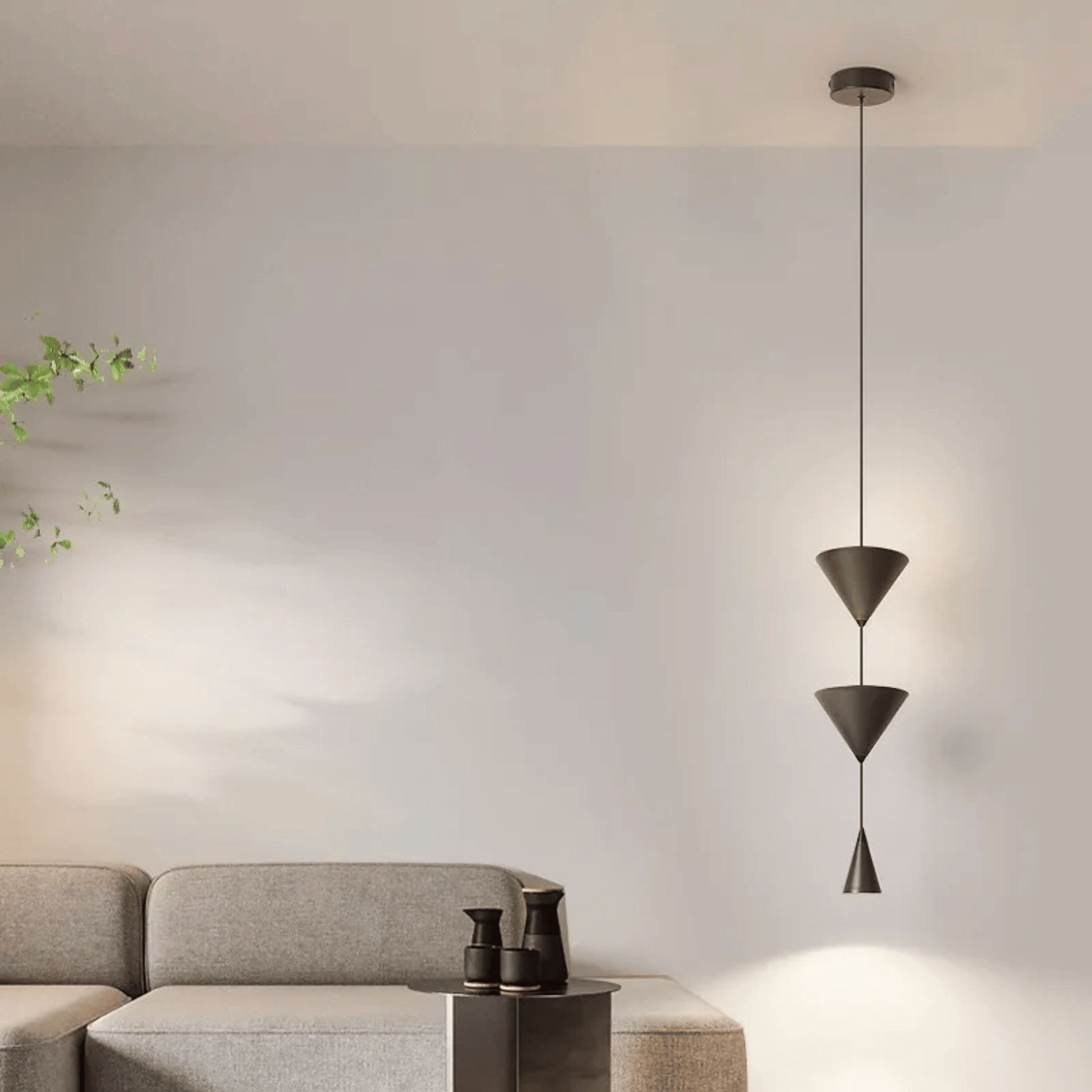 Modern pendant light hanging in a living room with a gray sofa and decorative items.