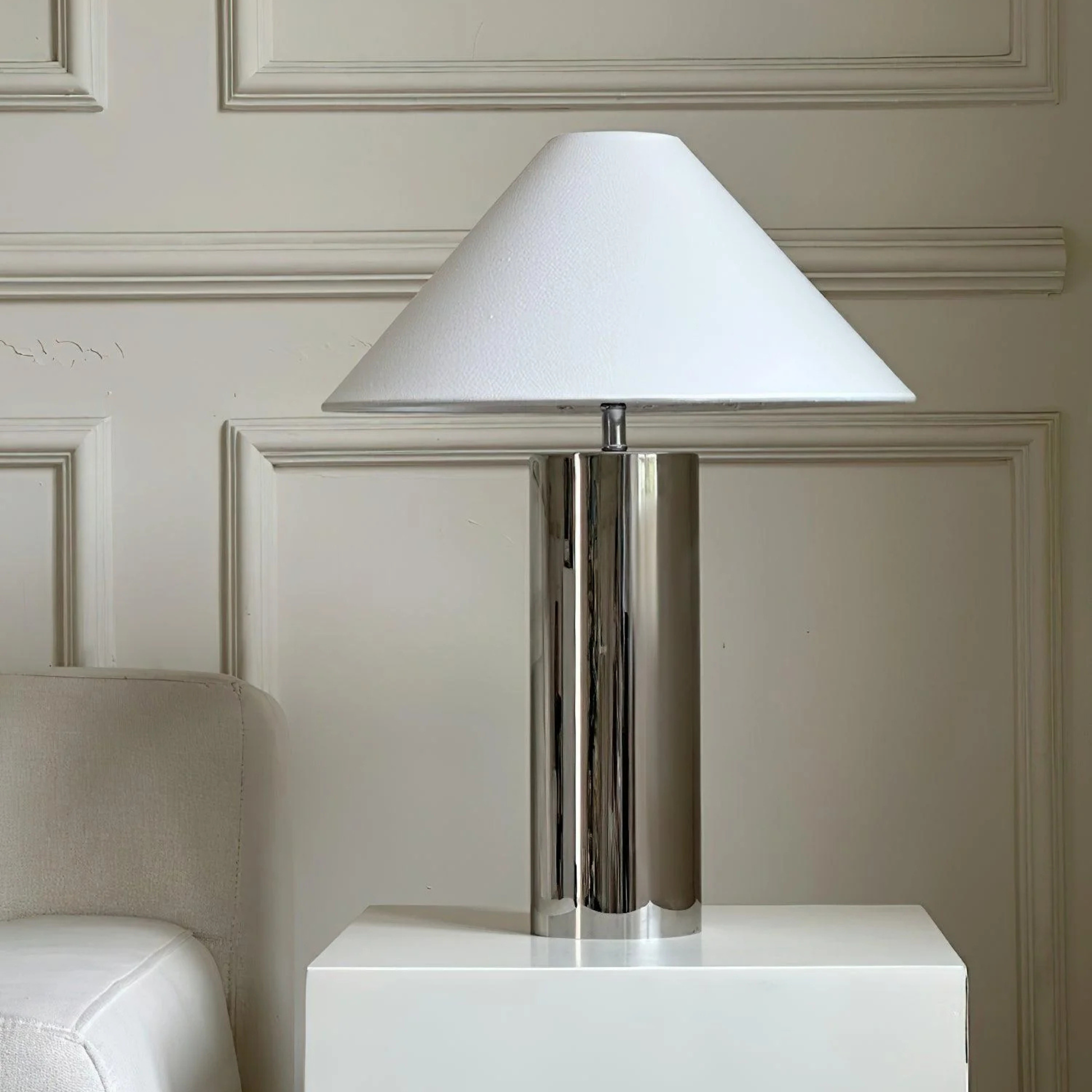 chrome table lamp on a white cube table in a neutral living room