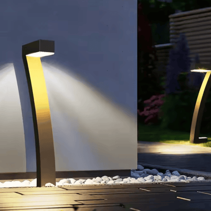 Modern outdoor garden light fixture illuminating a pathway at night.