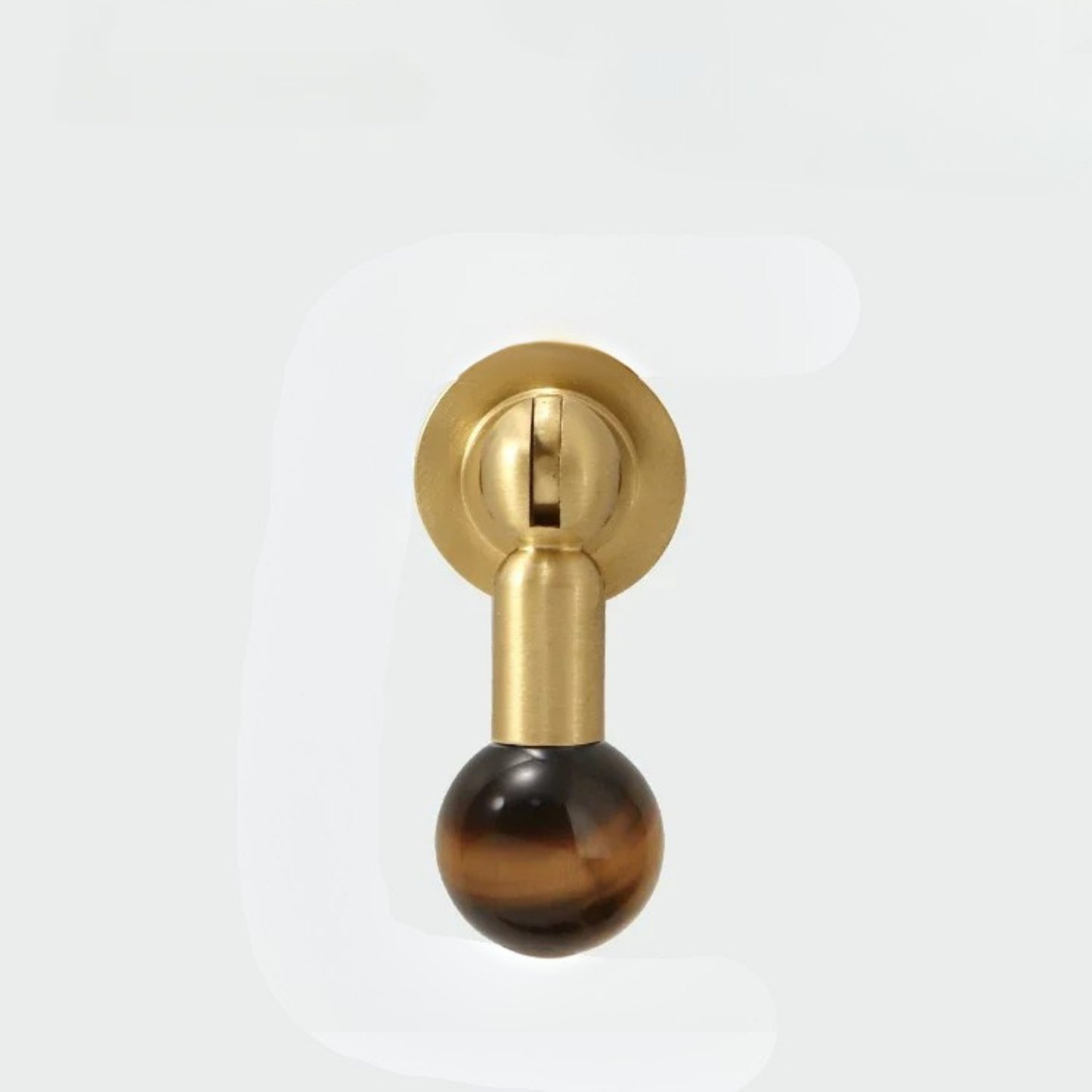 Single brass knob with polished brown gemstone sphere handle on a plain white background.