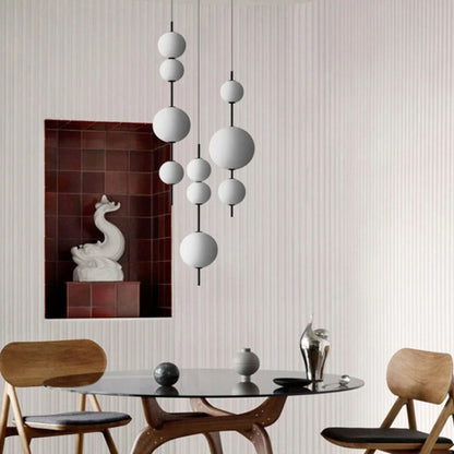 A close-up view of a cluster of three round pendant lights hanging from the ceiling in a contemporary interior.