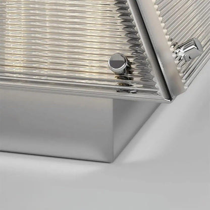 A close-up view of the lamp’s metallic base and pleated shade material.